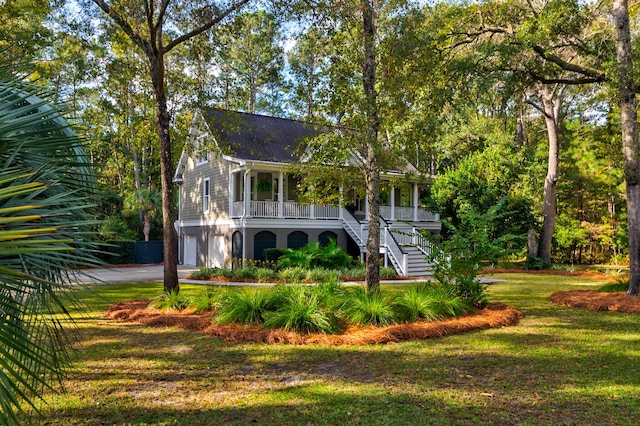 view of front facade with a front yard, a garage, and a porch