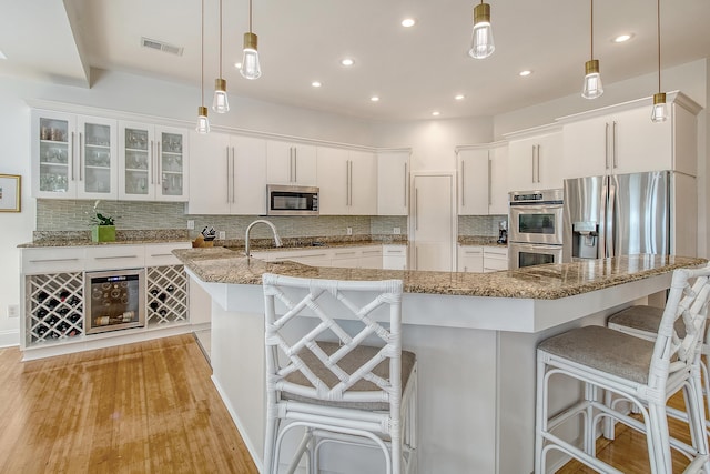 5084 Timber Race Crse, Hollywood, SC 29449 - kitchen with appliances with stainless steel finishes, white cabinets, a kitchen breakfast bar, decorative backsplash, and recessed lighting