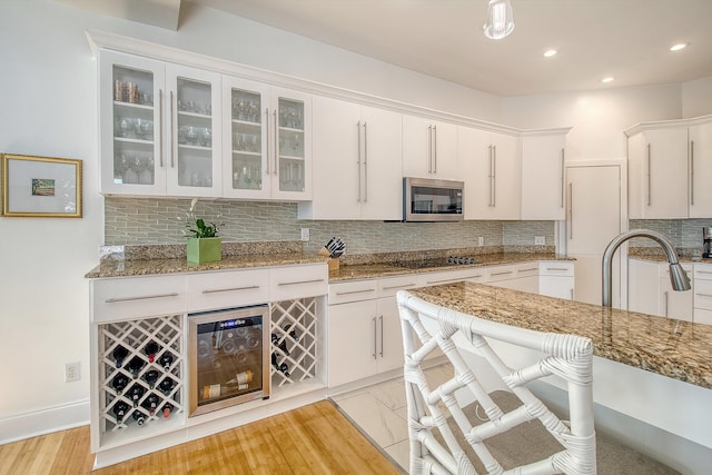 5084 Timber Race Crse, Hollywood, SC 29449 - kitchen featuring stainless steel microwave, wine cooler, backsplash, white cabinets, and recessed lighting