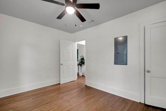 spare room featuring electric panel, hardwood / wood-style flooring, and ceiling fan