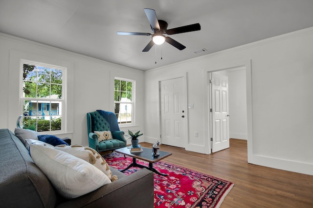 living room featuring hardwood / wood-style flooring, ceiling fan, and crown molding