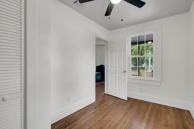 unfurnished bedroom featuring ceiling fan and dark wood-type flooring