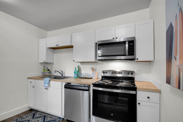 kitchen featuring white cabinetry, sink, stainless steel appliances, and dark hardwood / wood-style floors