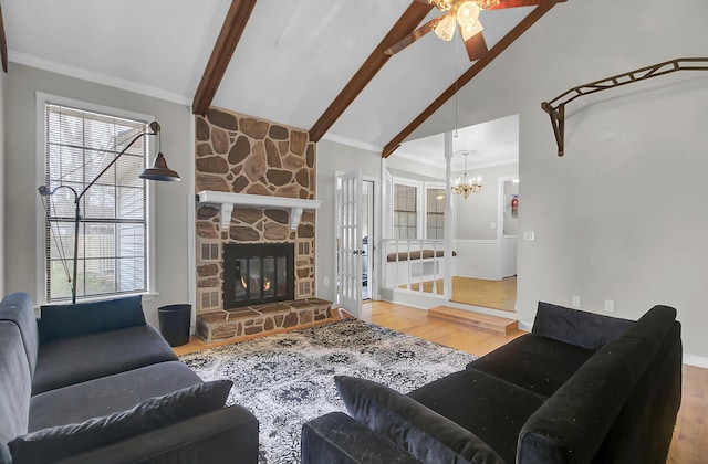 living area featuring vaulted ceiling with beams, a fireplace, wood finished floors, and crown molding