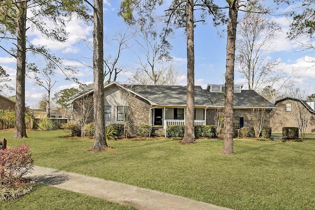 view of front of house with a front yard, covered porch, and brick siding