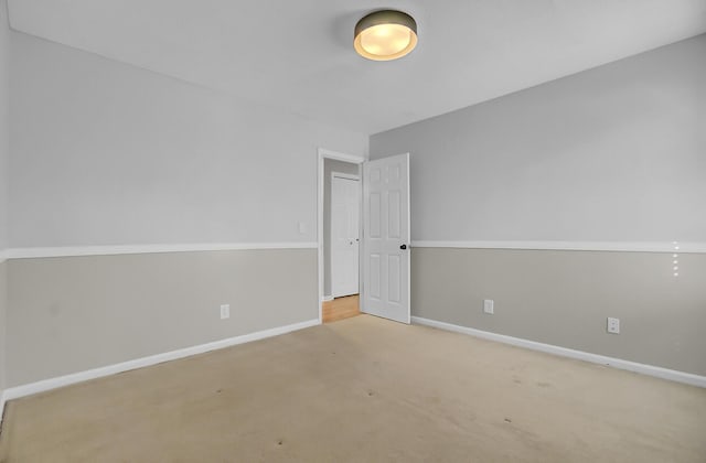 carpeted spare room featuring baseboards