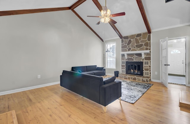 living area with baseboards, ceiling fan, wood finished floors, a fireplace, and beam ceiling