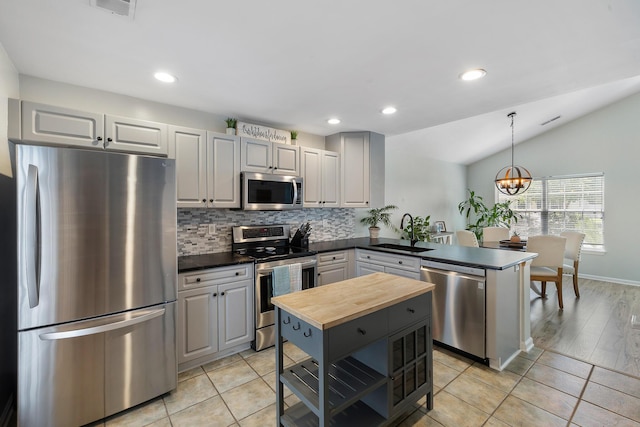 1136 Peninsula Cove Dr, Charleston, SC 29492 - kitchen with appliances with stainless steel finishes, butcher block counters, a sink, backsplash, and a peninsula