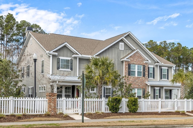 view of front facade with board and batten siding and a fenced front yard