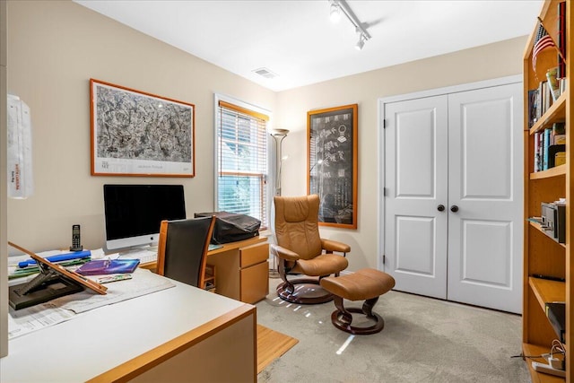 carpeted home office featuring track lighting