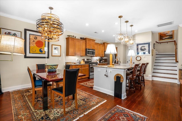 dining space with ornamental molding, a notable chandelier, and dark hardwood / wood-style floors