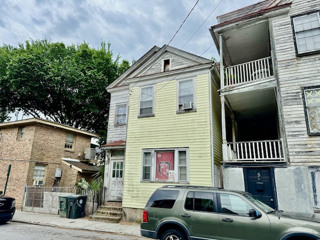 3 Hanover St, Charleston, SC 29403 - view of front of home featuring a balcony, central AC unit, entry steps, fence, and cooling unit