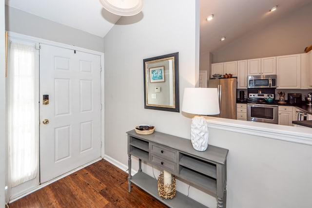 entryway with dark wood-type flooring, vaulted ceiling, and a healthy amount of sunlight