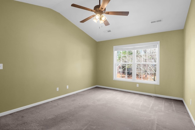 carpeted empty room with visible vents, lofted ceiling, baseboards, and ceiling fan