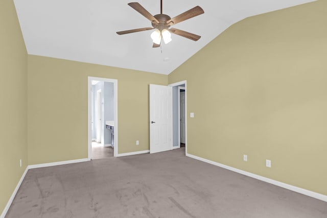 unfurnished bedroom featuring a ceiling fan, baseboards, lofted ceiling, carpet flooring, and connected bathroom