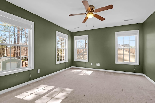 unfurnished room with visible vents, baseboards, carpet, and ceiling fan