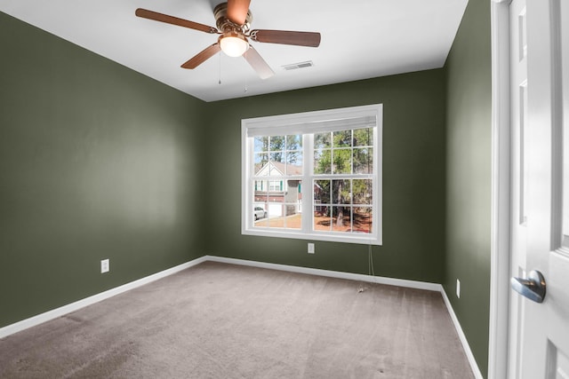 carpeted empty room with visible vents, a ceiling fan, and baseboards