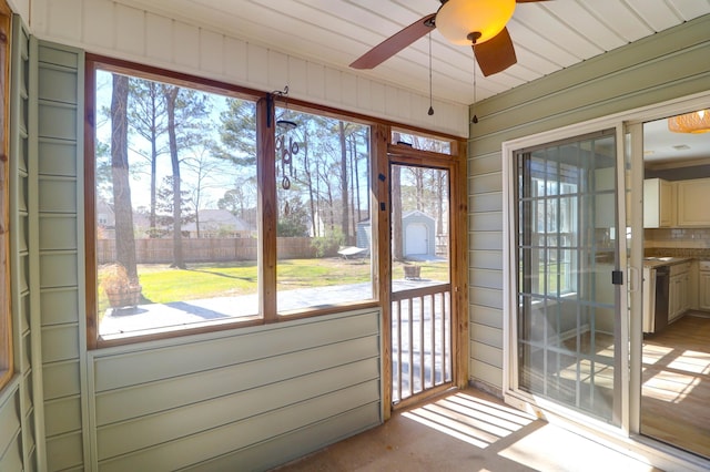 unfurnished sunroom with ceiling fan