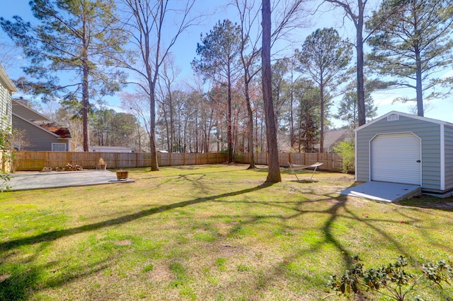 view of yard with a storage shed, an outbuilding, a fenced backyard, and a patio