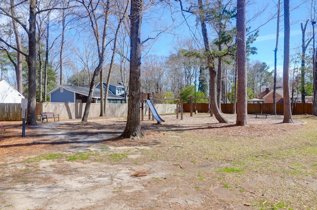 view of yard featuring playground community and fence