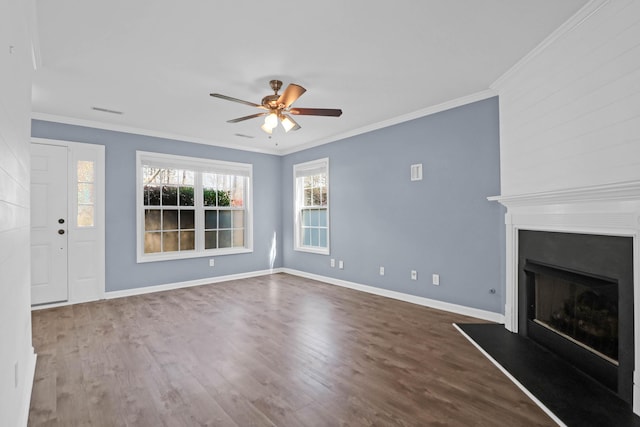 unfurnished living room with crown molding, wood finished floors, a fireplace with raised hearth, and baseboards