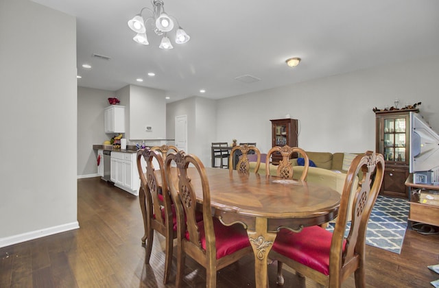 dining space with dark wood-type flooring and a notable chandelier