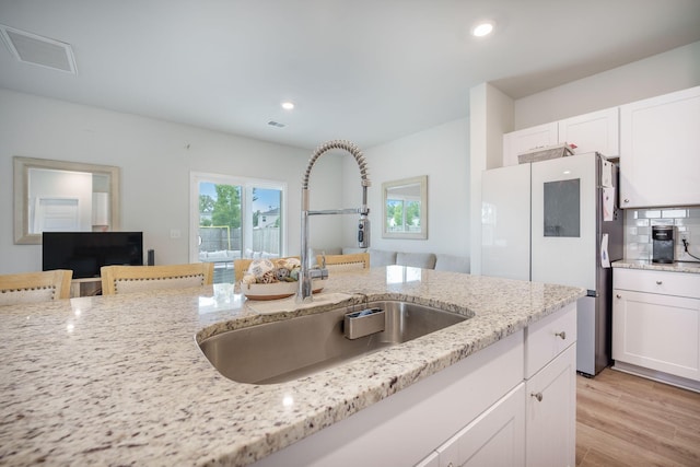 452 Minim St, Charleston, SC 29414 - kitchen featuring a sink, freestanding refrigerator, white cabinets, light stone countertops, and recessed lighting