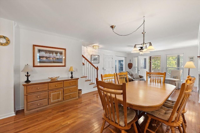 dining area featuring a chandelier, crown molding, and light hardwood / wood-style flooring