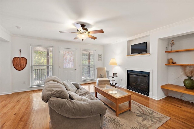 living room with light hardwood / wood-style flooring, ceiling fan, and crown molding