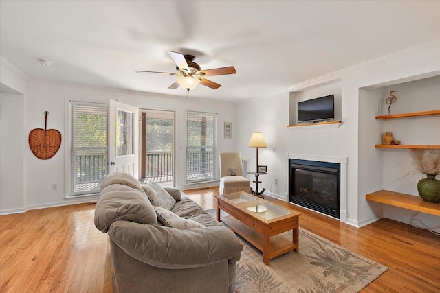 living room with light hardwood / wood-style floors, ceiling fan, and crown molding