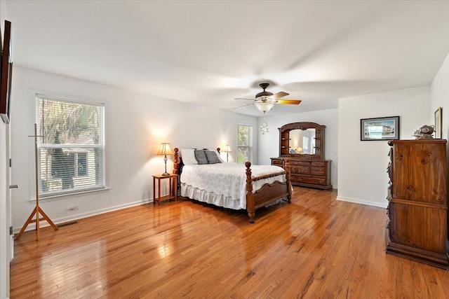 bedroom with ceiling fan, multiple windows, and wood-type flooring