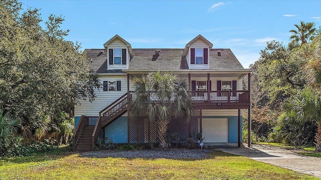 view of front of house featuring a garage, a front yard, and a porch