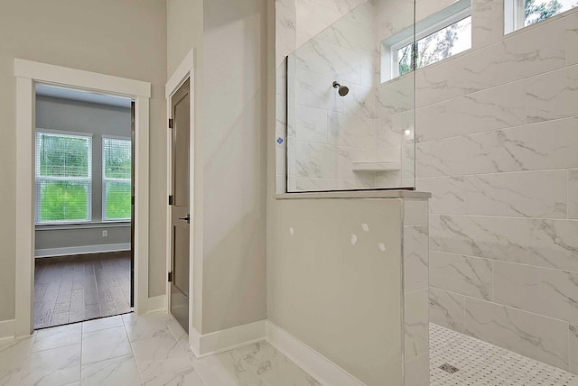 bathroom featuring tiled shower and a wealth of natural light