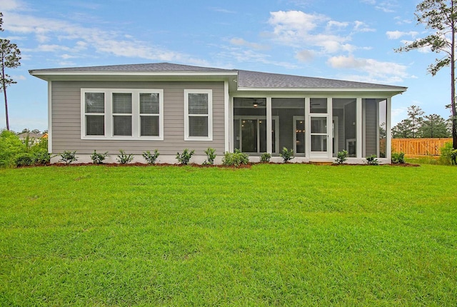 back of house featuring a yard and a sunroom