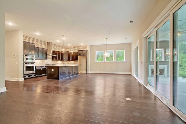 unfurnished living room featuring sink, brick wall, and dark hardwood / wood-style floors