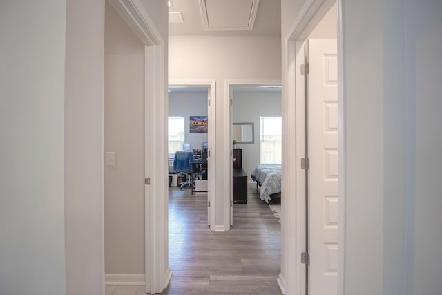 corridor featuring baseboards and wood finished floors
