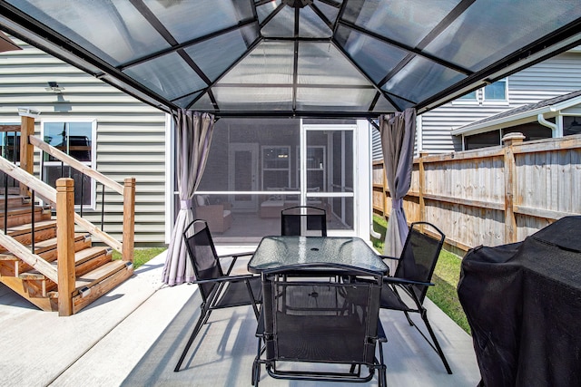 view of patio / terrace featuring a grill, outdoor dining space, a sunroom, fence, and a gazebo