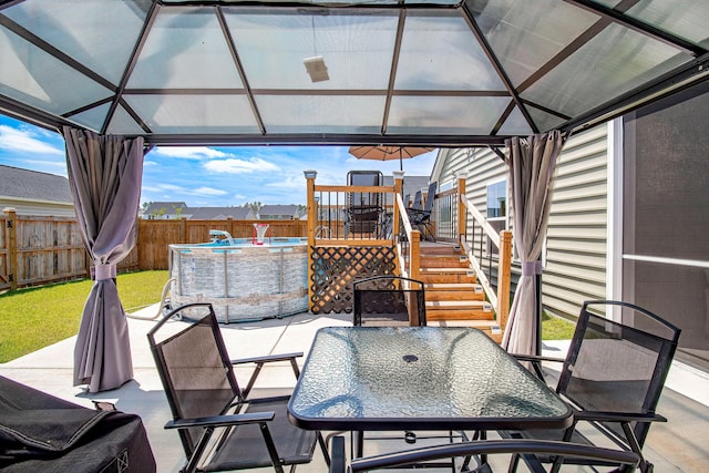 view of patio featuring a gazebo, outdoor dining space, a fenced in pool, and a fenced backyard