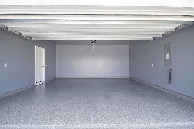 garage featuring electric panel, baseboards, and a garage door opener