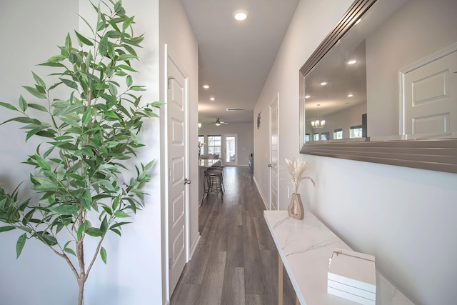 corridor with dark wood finished floors, visible vents, baseboards, and recessed lighting