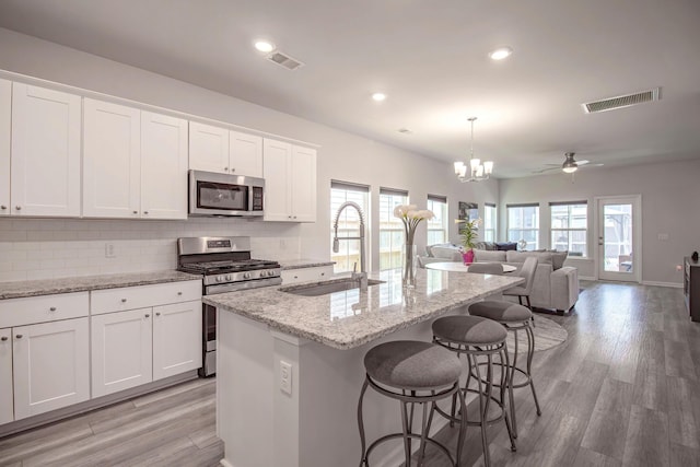kitchen with a healthy amount of sunlight, stainless steel appliances, visible vents, and a sink