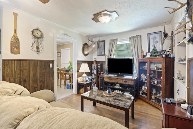 2703 Phyllis St, North Charleston, SC 29405 - living room featuring wainscoting, wood finished floors, wooden walls, a textured ceiling, and ornamental molding