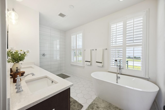 full bathroom featuring a freestanding tub, double vanity, a tile shower, and tile patterned floors