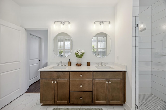 bathroom with tile patterned flooring, double vanity, and tiled shower