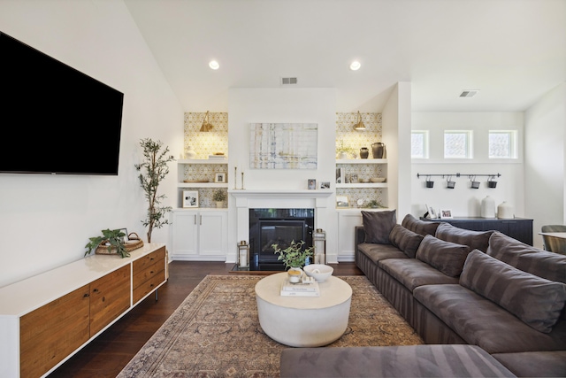 living area featuring dark wood-style flooring, a fireplace with flush hearth, and recessed lighting