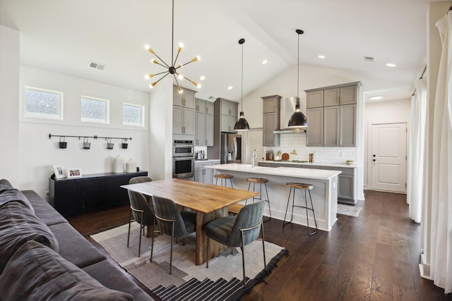 dining room featuring dark wood-type flooring, lofted ceiling, a chandelier, and recessed lighting
