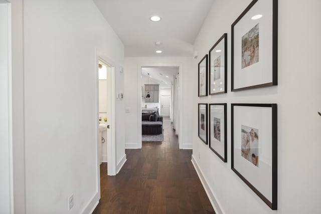 corridor featuring recessed lighting, dark wood-style flooring, and baseboards