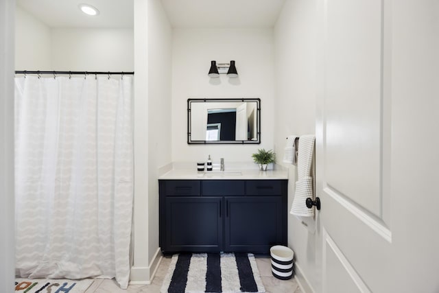 bathroom featuring vanity, baseboards, and recessed lighting