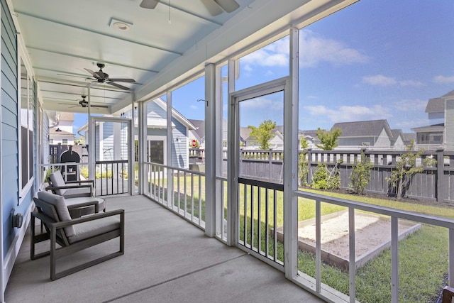 sunroom featuring ceiling fan and a residential view