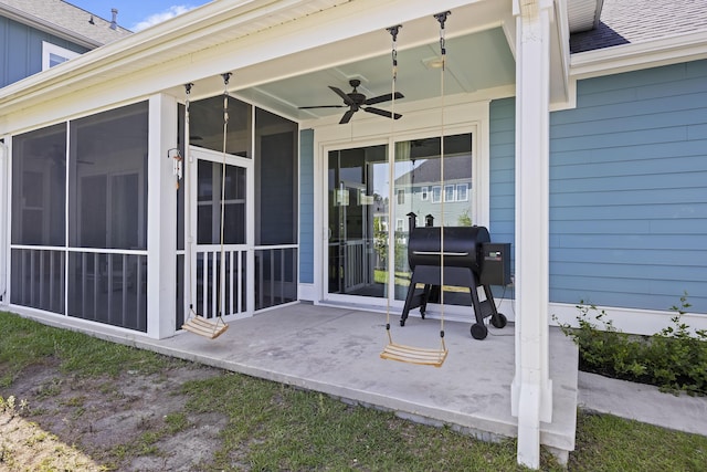 view of patio / terrace featuring a ceiling fan and a sunroom
